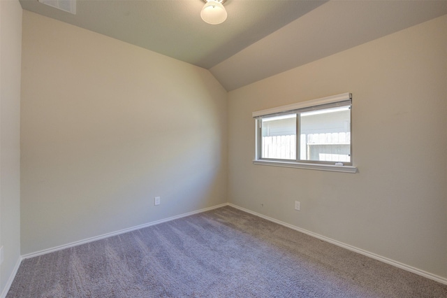 carpeted empty room with lofted ceiling, visible vents, and baseboards