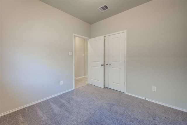 unfurnished bedroom with carpet floors, a closet, visible vents, and baseboards