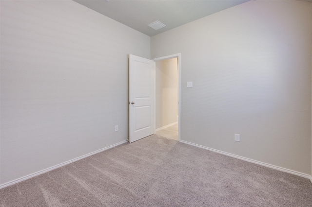 unfurnished room featuring light carpet and baseboards