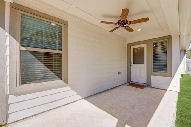 view of exterior entry featuring a ceiling fan and a patio