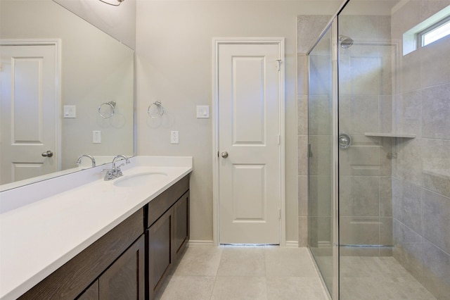 bathroom featuring tile patterned flooring, tiled shower, and vanity