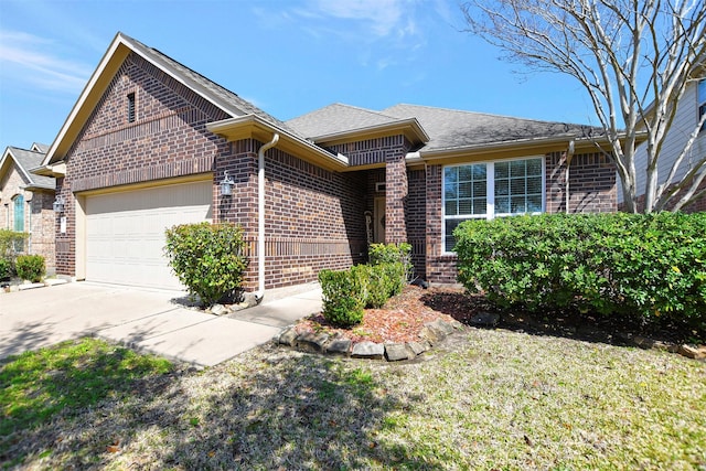 view of front facade with brick siding, driveway, an attached garage, and roof with shingles