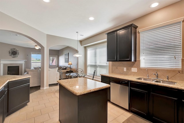 kitchen with dishwasher, open floor plan, arched walkways, and a sink