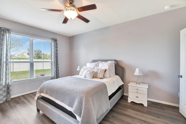 bedroom with a ceiling fan, baseboards, and wood finished floors