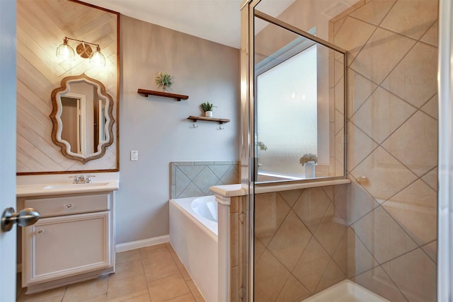 full bathroom with a stall shower, vanity, tile patterned flooring, baseboards, and a bath