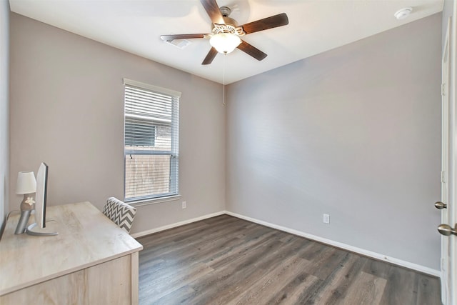 unfurnished office featuring ceiling fan, dark wood-style flooring, and baseboards