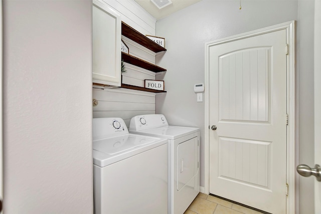 laundry room featuring cabinet space, light tile patterned floors, visible vents, and washer and clothes dryer