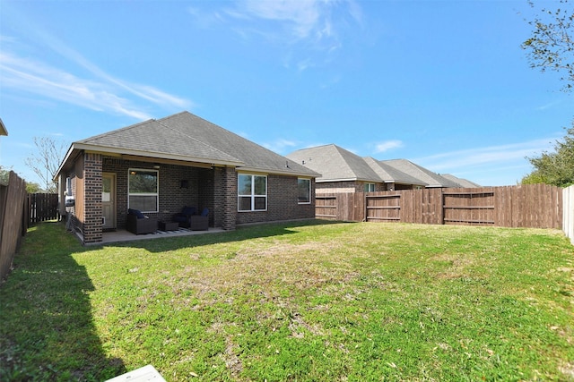 rear view of property featuring a patio, a fenced backyard, brick siding, a lawn, and roof with shingles