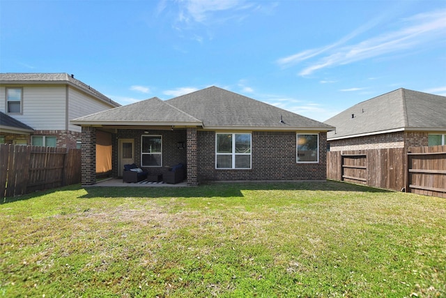 back of house with a yard, a fenced backyard, a patio, and brick siding