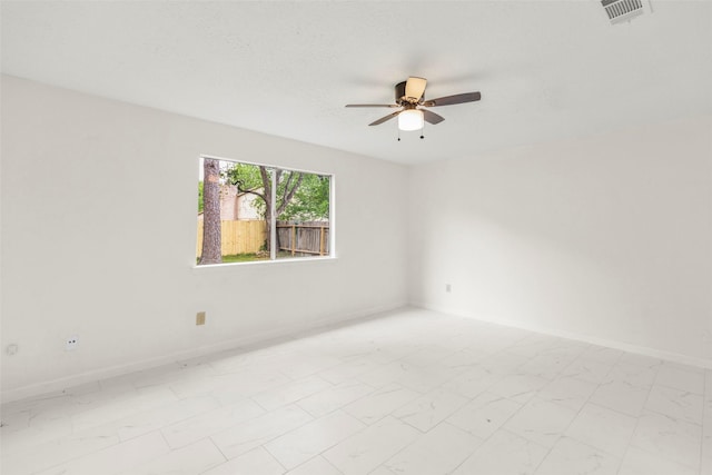 spare room featuring baseboards, visible vents, a ceiling fan, marble finish floor, and a textured ceiling