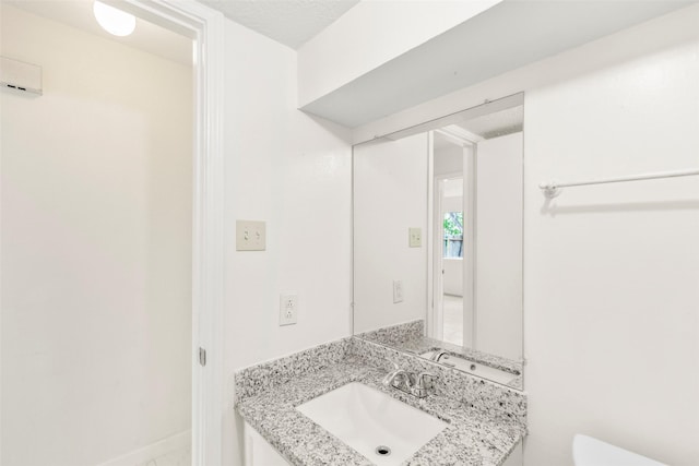 bathroom featuring baseboards, vanity, and toilet