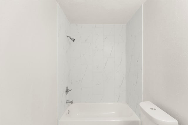 bathroom featuring  shower combination, a textured ceiling, and toilet