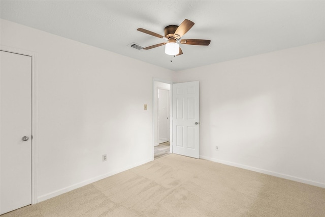 unfurnished bedroom with baseboards, a ceiling fan, visible vents, and light colored carpet