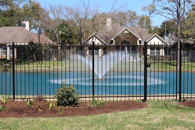 view of pool featuring fence and a water view