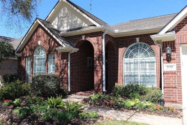 view of exterior entry featuring brick siding