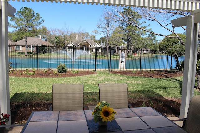 view of yard with a patio, fence, and a water view