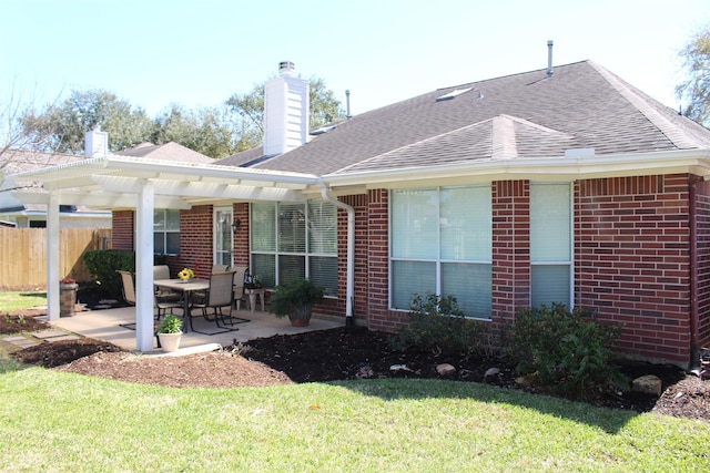 rear view of house featuring a patio, fence, roof with shingles, a pergola, and brick siding