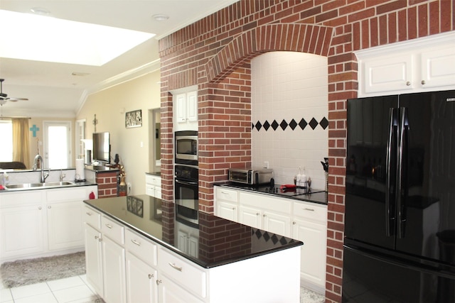 kitchen featuring a kitchen island, ornamental molding, a sink, black appliances, and dark countertops