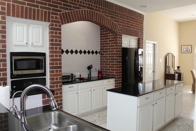 kitchen with stainless steel microwave, white cabinetry, dark countertops, and freestanding refrigerator