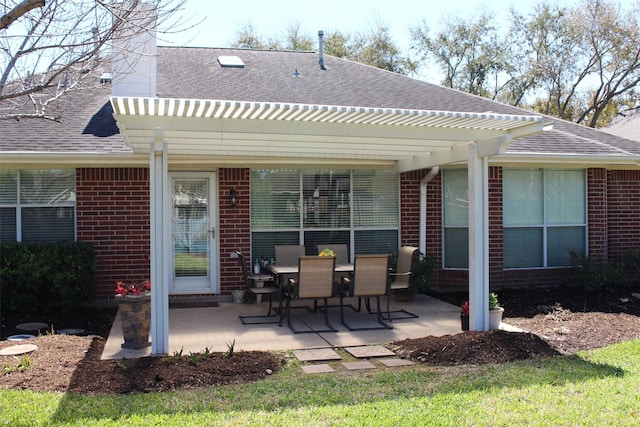 back of house featuring brick siding, a shingled roof, and a patio area