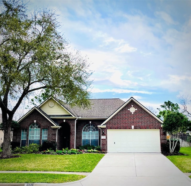 single story home featuring a garage, a front lawn, brick siding, and driveway