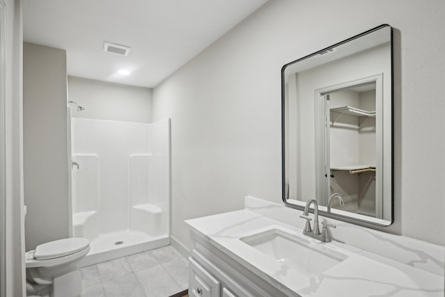 bathroom with visible vents, vanity, toilet, and a walk in shower