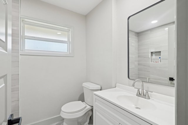 bathroom featuring vanity, toilet, and baseboards