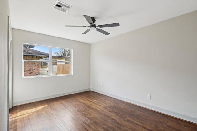 spare room with ceiling fan, hardwood / wood-style flooring, visible vents, and baseboards