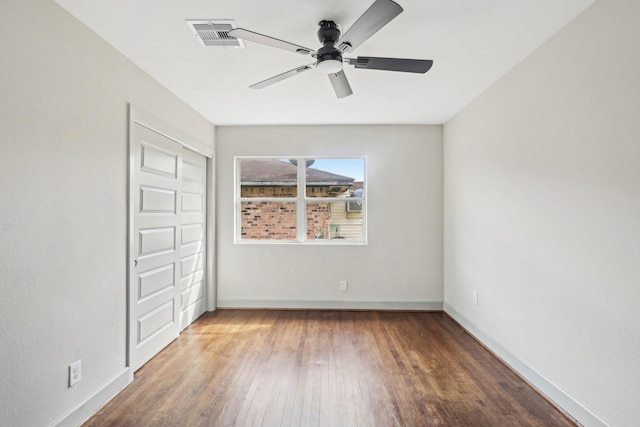 unfurnished bedroom featuring a closet, visible vents, a ceiling fan, wood finished floors, and baseboards