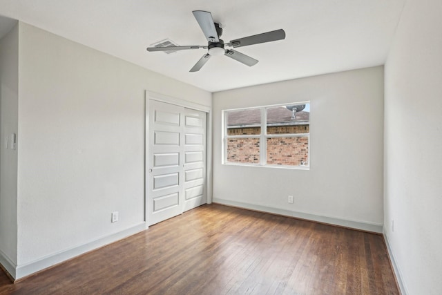 unfurnished bedroom featuring wood finished floors, visible vents, a ceiling fan, baseboards, and a closet