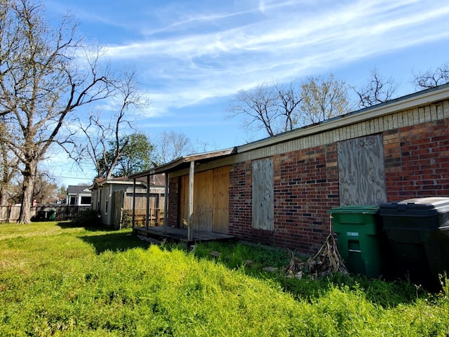 view of home's exterior featuring brick siding and a lawn