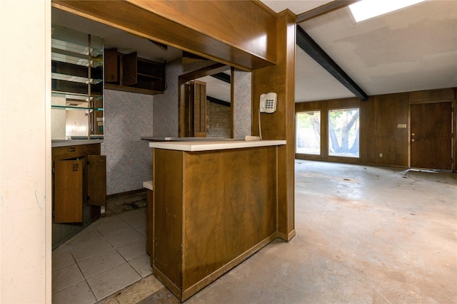 kitchen featuring beam ceiling, light countertops, and unfinished concrete flooring