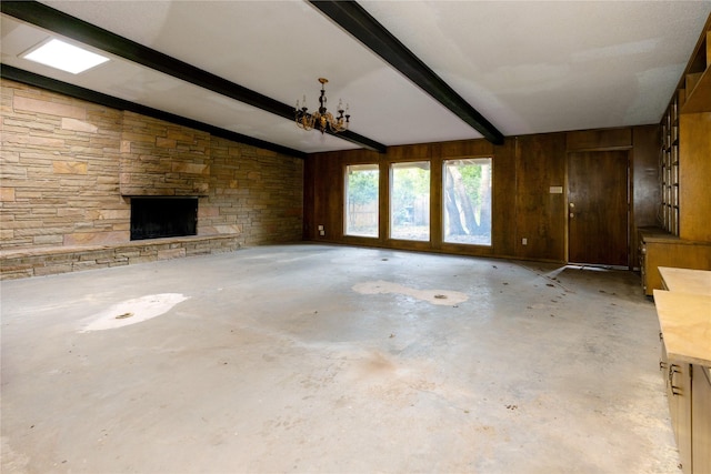 unfurnished living room featuring lofted ceiling with beams, wooden walls, a fireplace, and concrete flooring