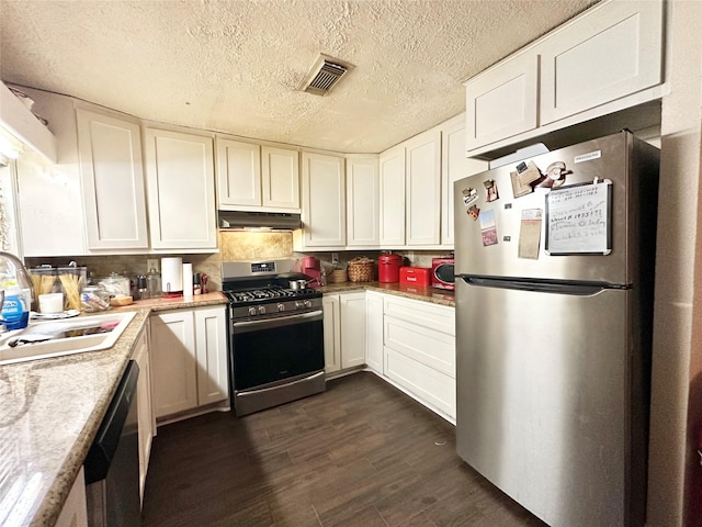 kitchen with visible vents, dark wood-style flooring, stainless steel appliances, under cabinet range hood, and a sink