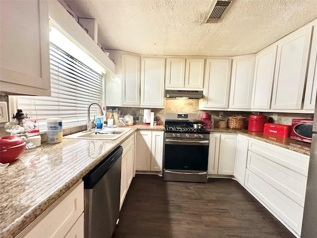 kitchen with stainless steel appliances, visible vents, white cabinets, a sink, and under cabinet range hood