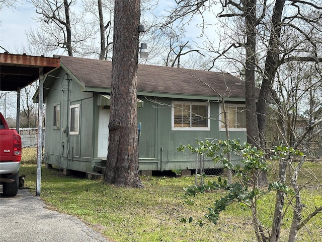 view of front of home featuring a shingled roof and a carport