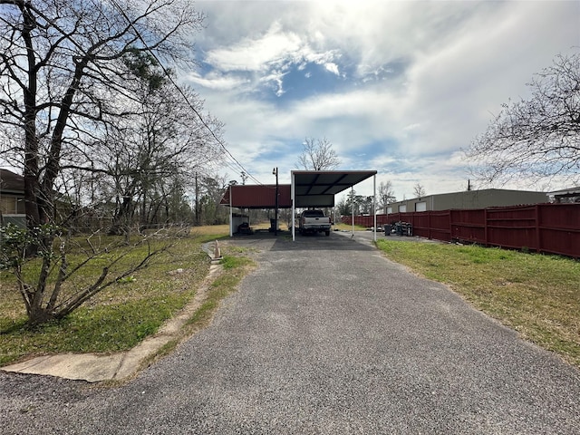 view of front of property with driveway, fence, and a carport