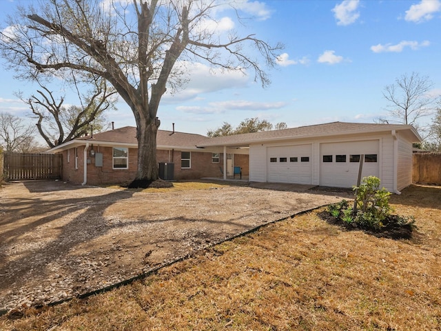 ranch-style house with central AC, dirt driveway, fence, an attached garage, and brick siding