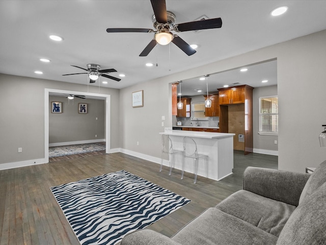 living area featuring dark wood finished floors, recessed lighting, and baseboards