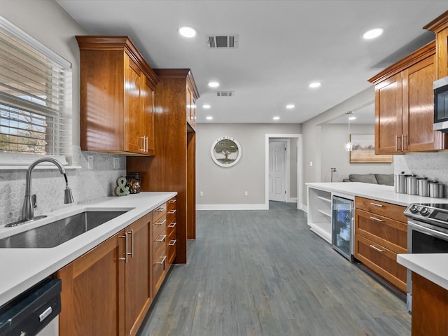 kitchen with visible vents, beverage cooler, brown cabinets, appliances with stainless steel finishes, and a sink