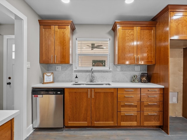 kitchen with stainless steel dishwasher, light countertops, brown cabinets, and a sink