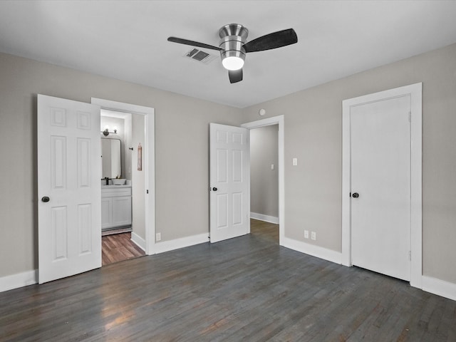 unfurnished bedroom with visible vents, dark wood-type flooring, ensuite bathroom, baseboards, and ceiling fan