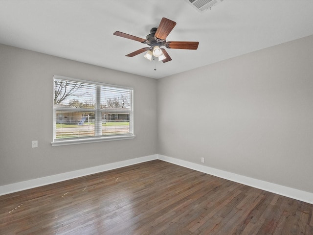 empty room featuring visible vents, ceiling fan, baseboards, and wood finished floors