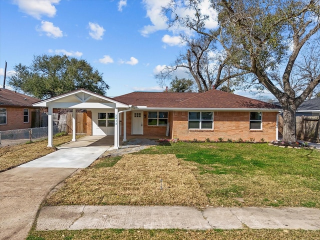 single story home featuring fence, concrete driveway, a front yard, a carport, and brick siding