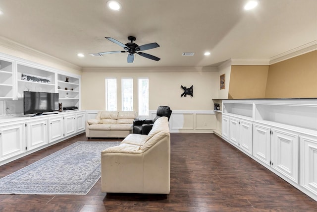 living area with a wainscoted wall, crown molding, visible vents, dark wood-type flooring, and ceiling fan