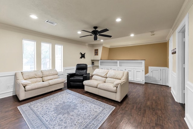 living room featuring ornamental molding, wainscoting, dark wood finished floors, and visible vents