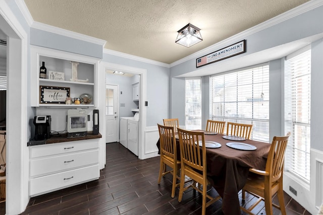 dining area featuring ornamental molding, wood finish floors, washer and clothes dryer, and a textured ceiling