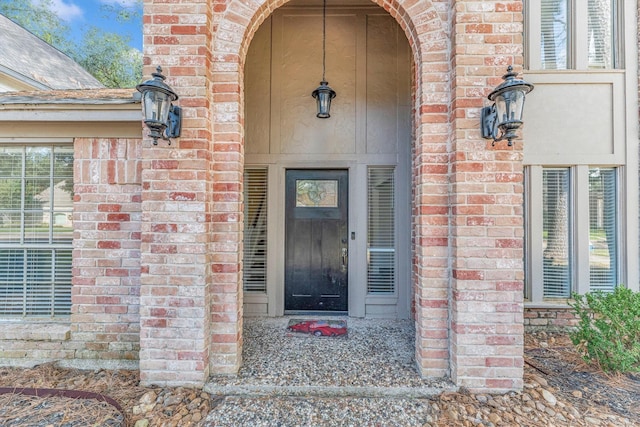 view of exterior entry featuring brick siding