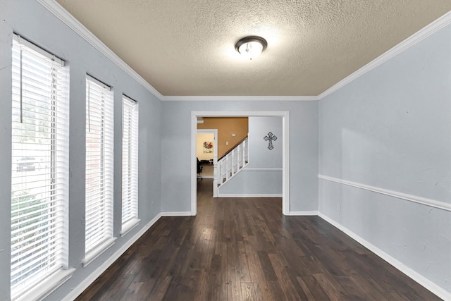 spare room with baseboards, crown molding, hardwood / wood-style floors, and stairs