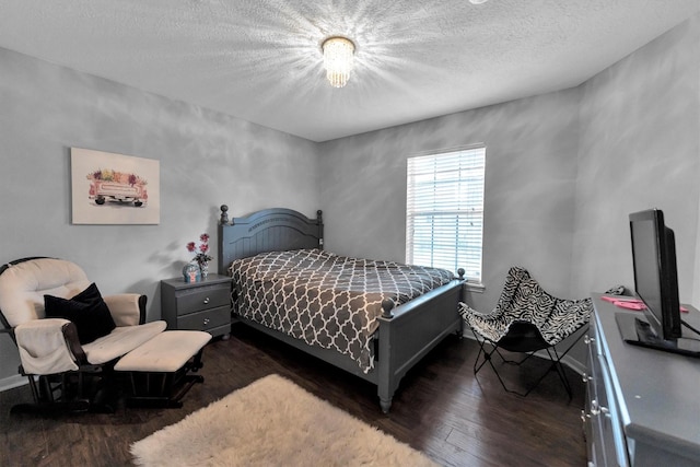 bedroom with a textured ceiling and dark wood-type flooring